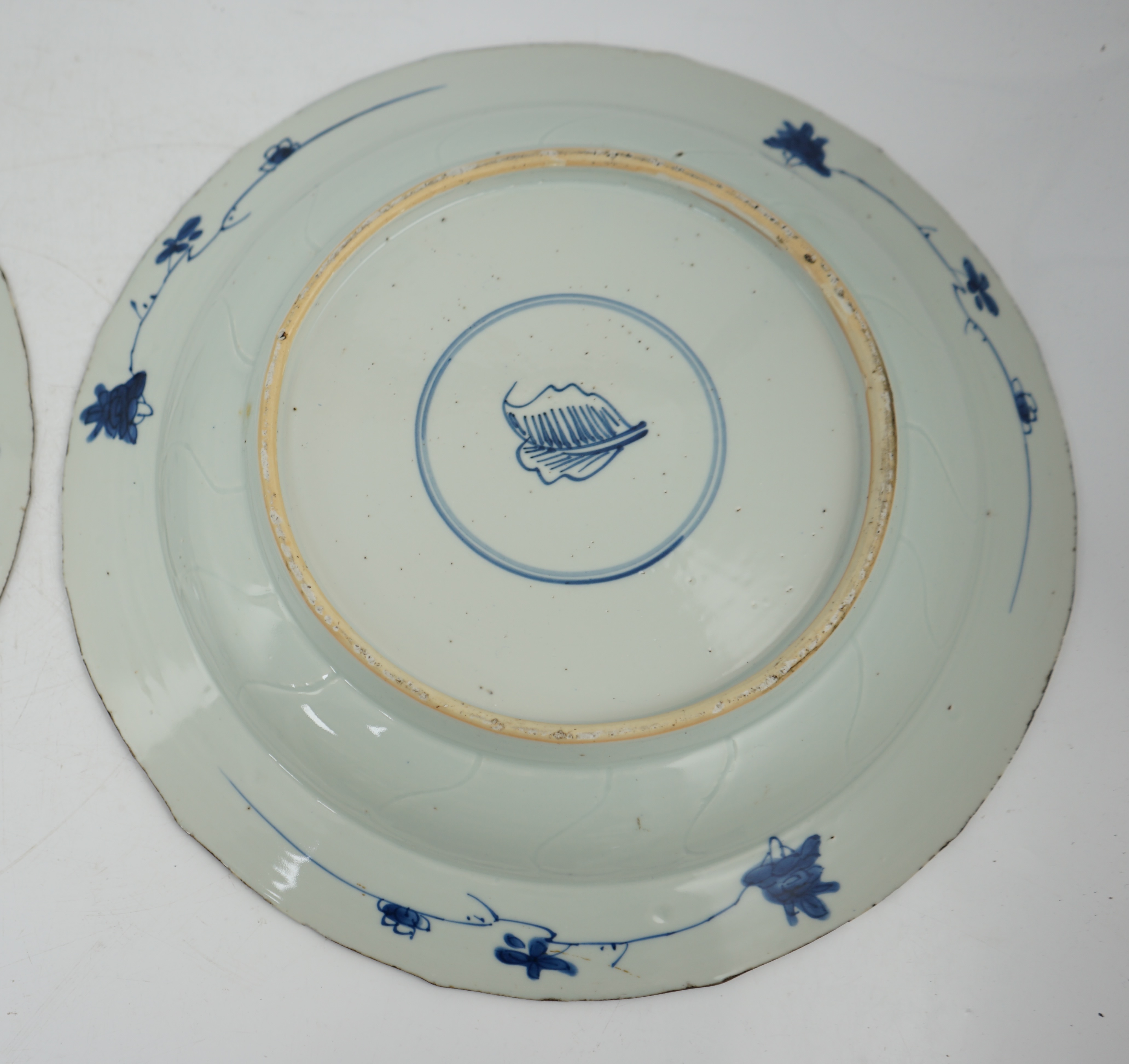 A pair of Chinese blue and white ‘garden’ dishes, Kangxi period, fritting and glaze chips